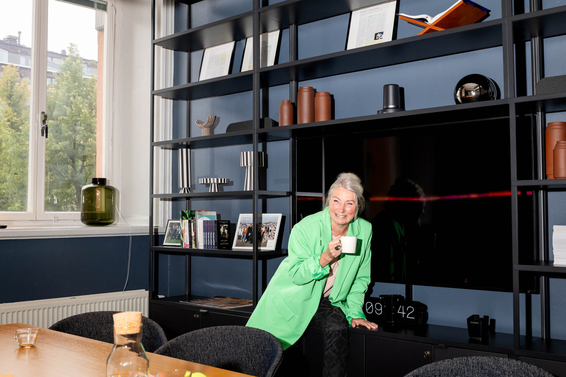 Kvinna i grön kavaj arbetar som Talent Acquisition Specialist i ett konferensrum.